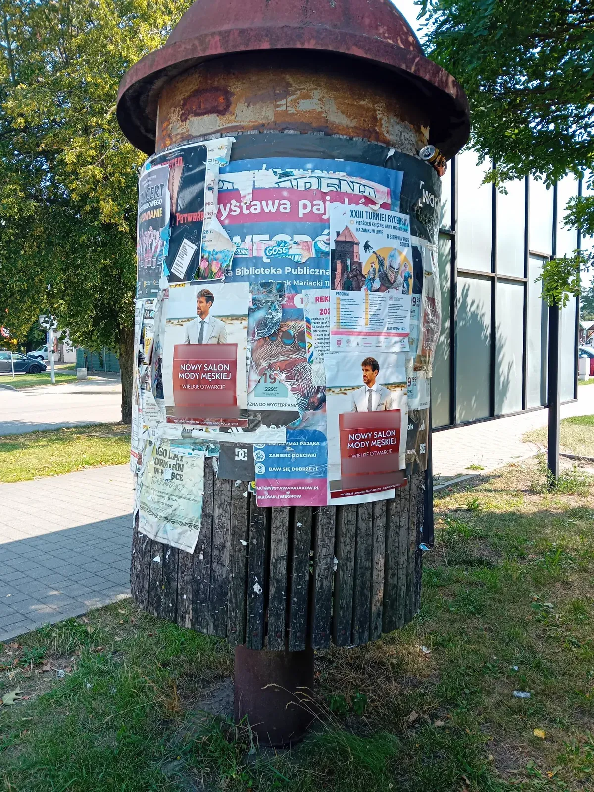 Dwa plakaty otwarcia salonu na słupie ogłoszeniowym w Węgrowie